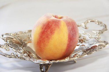 Süslü tabakta kırmızı şeftali meyvesi