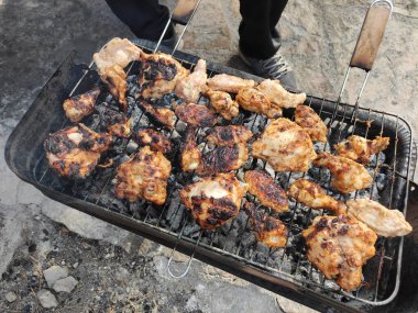Kızarmış tavuk parçalarından yapılmış lezzetli şiş kebap kızgın kömürde metal ızgarada.
