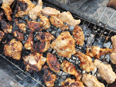 Kızarmış tavuk parçalarından yapılmış lezzetli şiş kebap kızgın kömürde metal ızgarada.