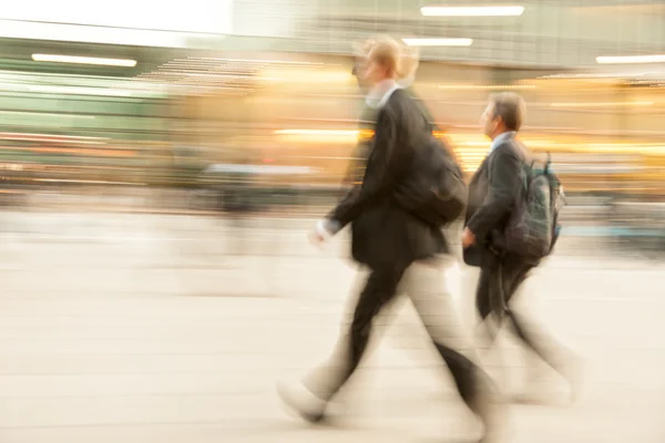 Geschäftsleute gehen an einem Bürogebäude vorbei — Stockfoto