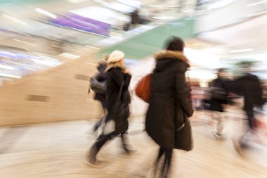 Alışveriş merkezinde yürüyen insanlar.