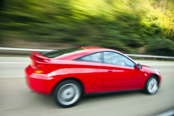 Kent, England, 15 September 2015: Red car driving fast on country road — Stock Photo, Image