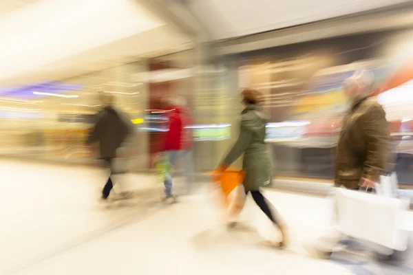 Centro comercial borroso, gente corriendo por el pasillo, efecto zoom — Foto de Stock