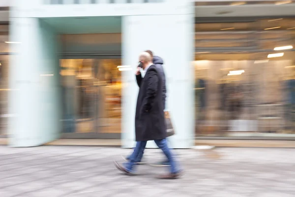 Un comprador caminando contra el escaparate — Foto de Stock