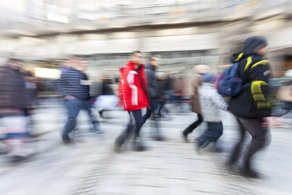 Wandelende mensen in de winkelstraat in de schemering — Stockfoto