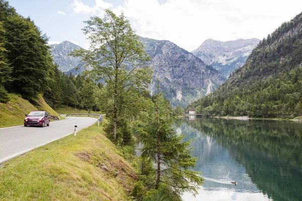 Ettal, Alemania, 23 de julio de 2015: Red car speeding on alpine road, A — Foto de Stock