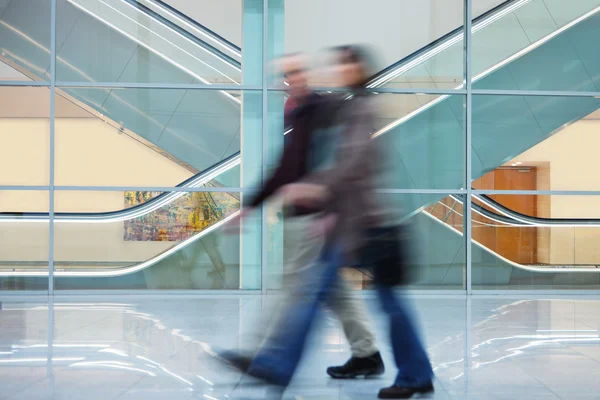 Zwei Personen laufen schnell Flur in Bürogebäude hinunter — Stockfoto
