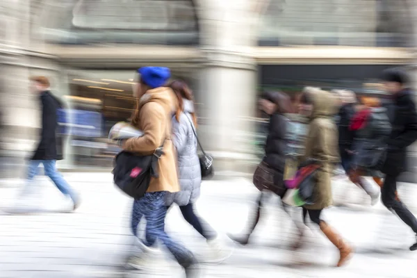 En shopper går foran butiksvinduet - Stock-foto