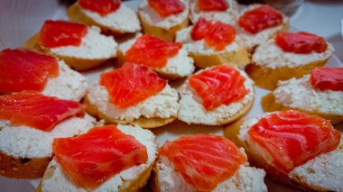 Süzme peynirli küçük kanepeler ve bir parça tuzlanmış somon..