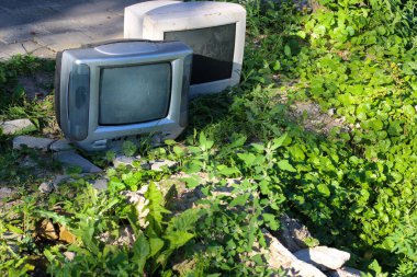 Bir çağın sonunun sembolü. Lamba TV ve bilgisayar monitörü eski kayalar ve çimenlerin arasına atılıyor..