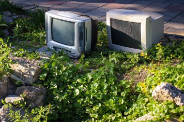 Bir çağın sonunun sembolü. Lamba TV ve bilgisayar monitörü eski kayalar ve çimenlerin arasına atılıyor..