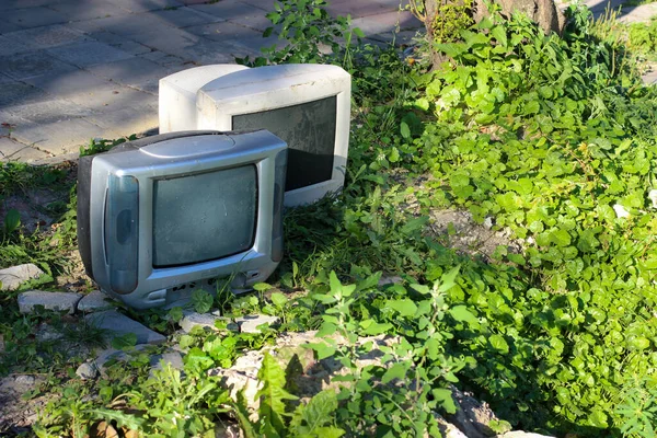 Bir çağın sonunun sembolü. Lamba TV ve bilgisayar monitörü eski kayalar ve çimenlerin arasına atılıyor..