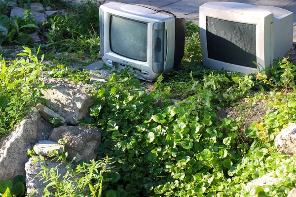 Bir çağın sonunun sembolü. Lamba TV ve bilgisayar monitörü eski kayalar ve çimenlerin arasına atılıyor..