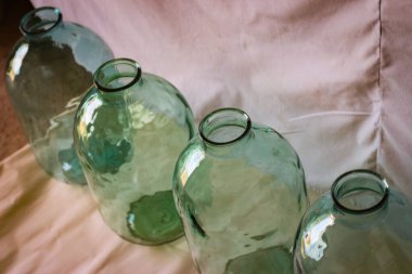 Arka planda kocaman cam kavanozlar.