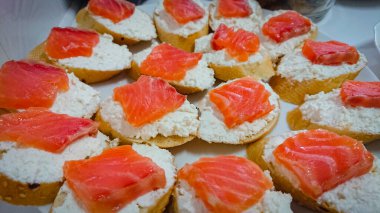 Süzme peynirli küçük kanepeler ve bir parça tuzlanmış somon..