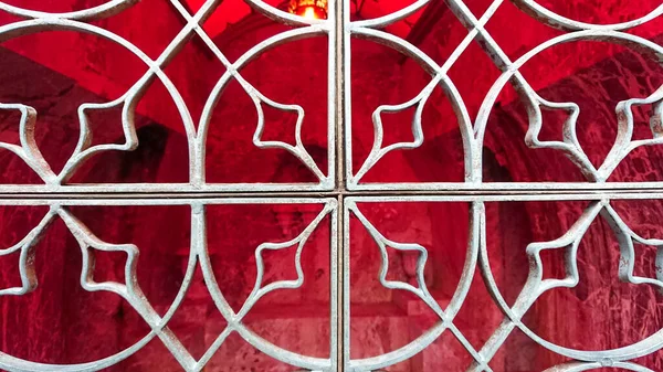 Kırmızı Arka Planda Eski Metal Işlenmiş Demir Pencere Izgarası — Stok fotoğraf