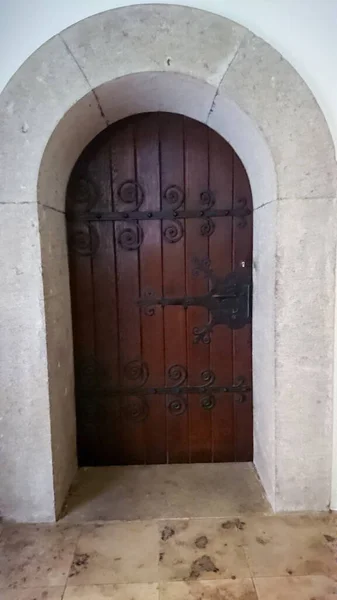 金属細工の鉄の要素を持つ石の壁に古い木製のドア — ストック写真