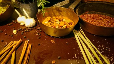 Akşam ışıklarıyla kahverengi bir masada mutfak çeşnileri. Tarçın, karabiber, kakule, badian (ayrıca yıldız anason bilir) ve diğerleri