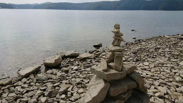 Rock balancing (or stone balancing) figure on lake shore