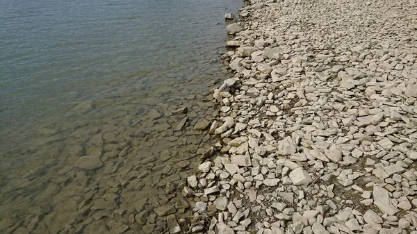石の海岸だ 小さな石の一部は水の中にあり 一部は乾燥したまま — ストック写真