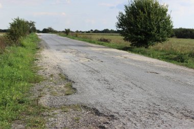 Terk edilmiş arazi yolu asfalt kaldırımlarla kaplı.