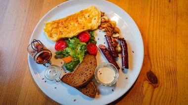 Lezzetli ve lezzetli bir kahvaltı. Yağda yumurta, sosis, şampiyon, marul ve domates.