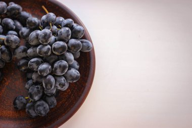 Kopya alanı olan bir tabakta mavi üzümler