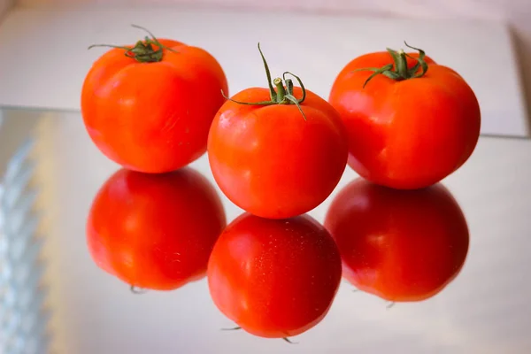 Varios Tomates Rojos Una Superficie Espejo — Foto de Stock