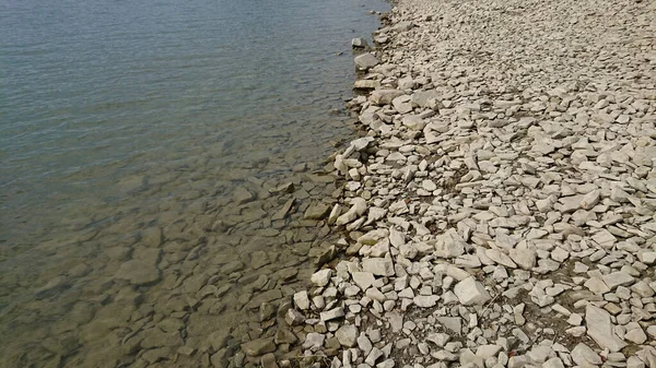 石の海岸だ 小さな石の一部は水の中にあり 一部は乾燥したまま — ストック写真