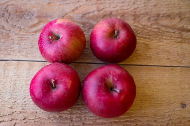 Kırmızı elmalar tahta bir yüzeyde durur.