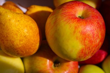 Birbirinin üstünde duran birkaç kırmızı-yeşil elma.