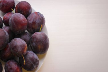 Fotokopi alanı olan beyaz bir arkaplanda olgunlaşmış erikler iştah açıcı