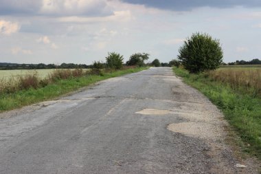 Terk edilmiş arazi yolu asfalt kaldırımlarla kaplı.