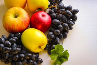 Düşen meyveler canlıdır. Hafif bir zemin üzerinde üzüm ve elmalar kopyalama için yer var