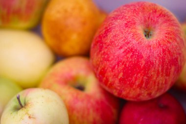 Birbirinin üstünde duran birkaç kırmızı-yeşil elma.