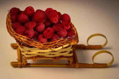 Olgun ahududu böğürtlenleri kızak şeklinde hasır bir sepete konur.