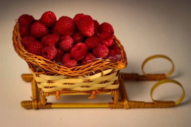 Olgun ahududu böğürtlenleri kızak şeklinde hasır bir sepete konur.