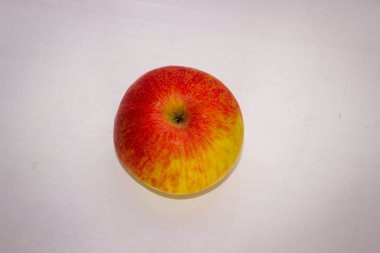 Beyaz arkaplanda bir kırmızı yeşil elma