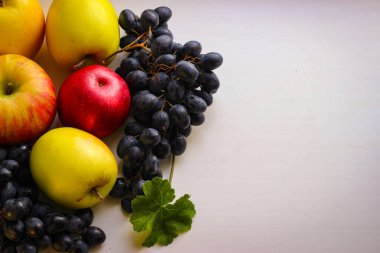 Düşen meyveler canlıdır. Hafif bir zemin üzerinde üzüm ve elmalar kopyalama için yer var