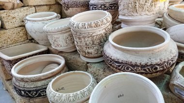 Çeşit çeşit desenli çiçekler için seramik kaplar mağazada duruyor