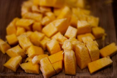 A beautiful and delicious fall background. A ripe pumpkin, sliced and diced