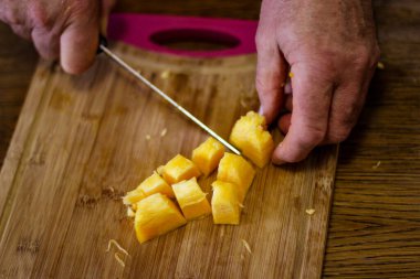 A man cuts pumpkin into pieces to make delicious pumpkin soup