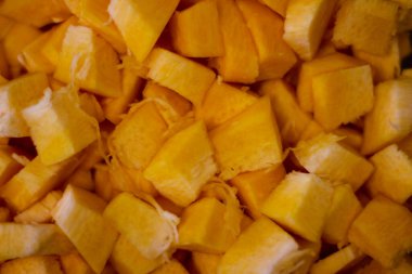 A beautiful and delicious fall background. A ripe pumpkin, sliced and diced