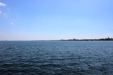Sopot plajının panoramik manzarası ve kırmızı çatıları, tarihi binaları ve Baltık Denizi 'nden görünen ormanlık tepeleri berrak mavi gökyüzü altında..