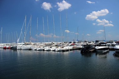 5 Haziran 2019 'da Polonya' nın Sopot limanına yanaşan yelkenli ve motorlu yatların görüntüsü. Sakin deniz ve dağınık bulutlu mavi gökyüzü. Sadece editör kullanımı.