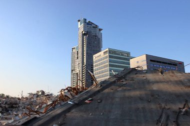 Polonya 'nın Gdynia kentindeki modern ofis binaları ve Su Kuleleri önünde enkaz ve moloz yığını olan bir yıkım alanı manzarası. Fotoğraf 5 Haziran 2019 'da çekildi..