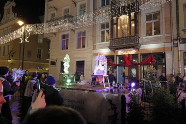 Poznan, Polonya, 12 Aralık 2025 - Poznan Buz Festivali sırasında şehir merkezinde akşam yürüyüşü. Aydınlanmış sokaklardaki ve buz heykel tesislerindeki kalabalıklar. Sadece yazı işleri için..