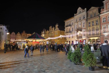 Poznan, Polonya, 12 Aralık 2025 - Poznan Buz Festivali sırasında şehir merkezinde akşam yürüyüşü. Aydınlanmış sokaklardaki ve buz heykel tesislerindeki kalabalıklar. Sadece yazı işleri için..