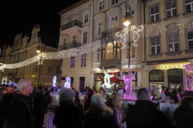 Poznan, Polonya, 12 Aralık 2025 - Poznan Buz Festivali sırasında şehir merkezinde akşam yürüyüşü. Aydınlanmış sokaklardaki ve buz heykel tesislerindeki kalabalıklar. Sadece yazı işleri için..