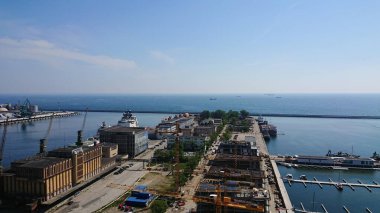 Açık bir yaz gününde Baltık Denizi kıyı şeridi boyunca liman gemileri ve liman altyapısı ile Gdynia limanının havadan görüntüsü.